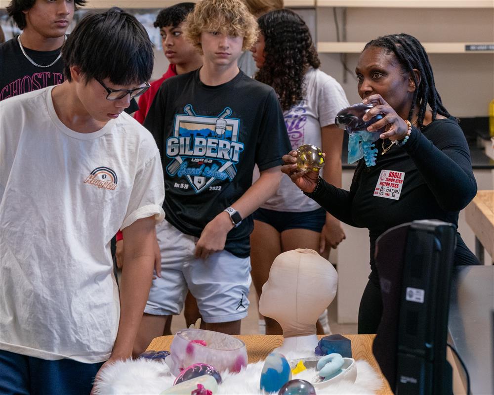 Students take a look at a guest speakers various models and displays she uses for work.